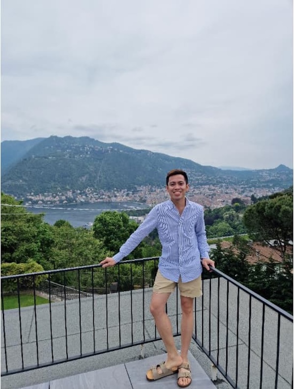 Image of someone standing infront of a balcony with a nice background